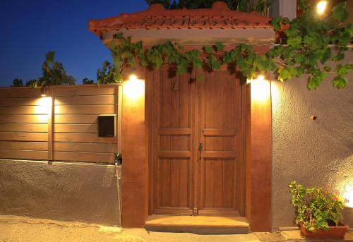 a wooden door on the side of a building with lights at Venetis Luxury Apartments in Chios