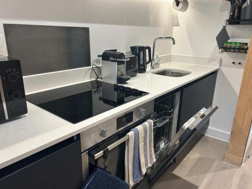 a kitchen with a sink and a counter top at Luxury new built split-level flat with rooftop gardens access in Manchester