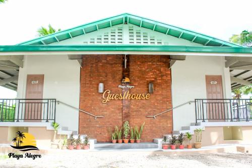 a building with a sign on the side of it at Playa Alegre Beach Resort & Restaurant in Tanauan