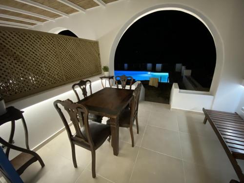 uma sala de jantar com uma mesa de madeira e cadeiras em SeaRock Rooms and Suites em Amorgós