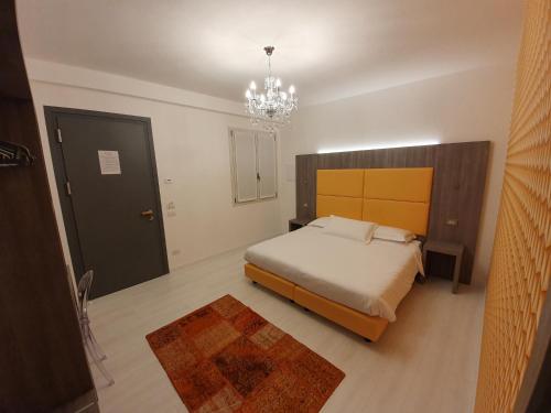 een slaapkamer met een bed en een kroonluchter bij Al Santuario in San Vito al Tagliamento