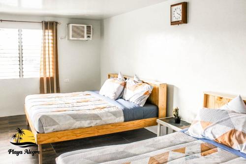 a bedroom with two beds and a window at Playa Alegre Beach Resort & Restaurant in Tanauan