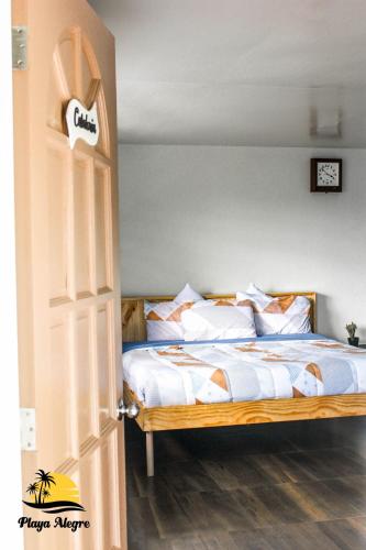 a bedroom with a bed with white blankets and pillows at Playa Alegre Beach Resort & Restaurant in Tanauan