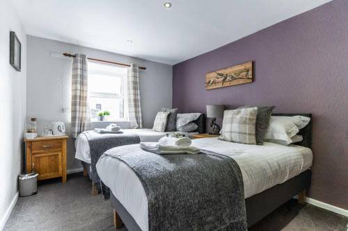 two beds in a bedroom with purple walls at Black Horse Hotel in Grassington