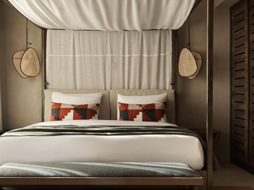 a bedroom with a bed with a canopy at Lindian Village All Inclusive Resort Rhodes,Curio Collection in Kiotari