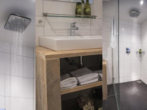 y baño con lavabo y ducha con toallas. en Erfgoed City House De Rozenboom, en Leeuwarden