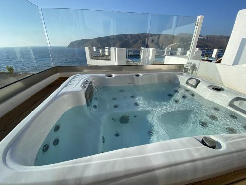 a bath tub with a view of the ocean at SeaRock Rooms and Suites in Amorgos