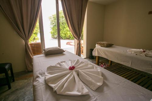 a room with two beds and a window at Hondaafushi Island Resort in Vaikaradhoo