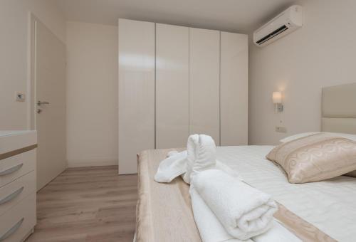 a white bedroom with white towels on a bed at Promajna Leone Erceg Apartments in Promajna