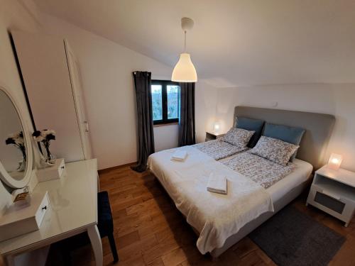 1 dormitorio con cama, escritorio y espejo en Villa Stone Pearl with heated swimming pool, en Sveti Filip i Jakov