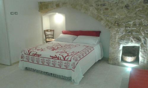 ガリポリにあるCase Vacanza Il Borgo Anticoの石壁のベッドルーム1室(ベッド1台付)
