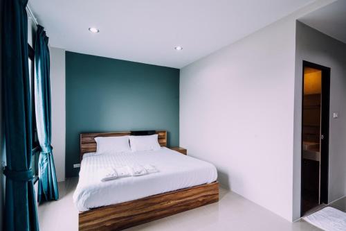 バンボーにあるThe Living Hotel SamutPrakanの青い壁のベッドルーム1室