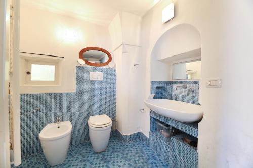 ガリポリにあるCase Vacanza Il Borgo Anticoの青いタイル張りのバスルーム(トイレ、シンク付)