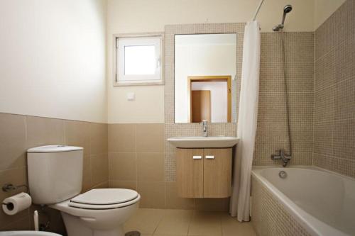 La salle de bains est pourvue de toilettes, d'un lavabo et d'une baignoire. dans l'établissement Apartamento Duja, à Cabanas de Tavira