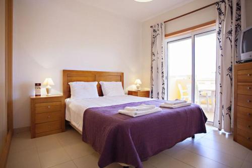 1 dormitorio con 1 cama con manta morada en Apartamento Duja en Cabanas de Tavira