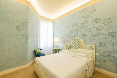 een slaapkamer met een bed en een muur met bloemenbehang bij Flat Volturno- Florentine neighbourhood in Florence