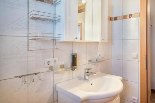 a white bathroom with a sink and a mirror at Appartement Julia in Achenkirch