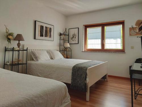 a bedroom with two beds and a window at Cottage, Casa do Laranjal - Near Gerês in Geres