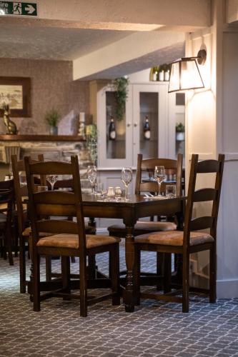a wooden table with chairs and wine glasses on it at Black Horse Hotel in Grassington