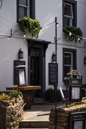 a white building with a sign in front of it at Black Horse Hotel in Grassington