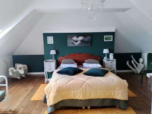 una camera con un letto con una parete verde di La Menardière L'appart' a Corseul