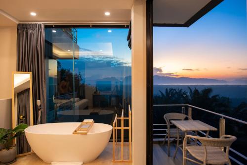 a bathroom with a bath tub on a balcony at Ao Luek Panoramic Pool-SHA Plus in Ao Luk