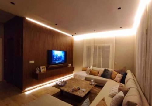 a living room with a couch and a tv at Villa lumias in Marrakesh