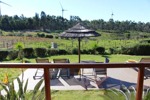 a patio with a table and an umbrella and chairs at Quinta das Alfambras in Aljezur