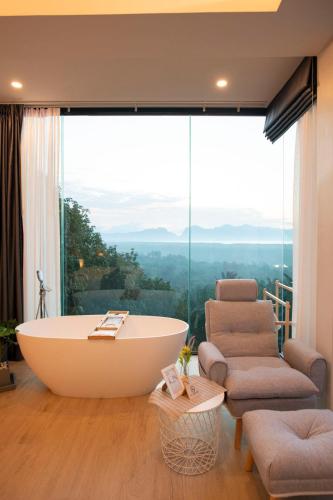 a bath tub in a room with a large window at Ao Luek Panoramic Pool-SHA Plus in Ao Luk