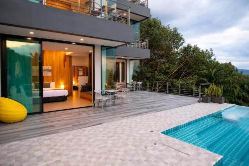 a house with a swimming pool and a bedroom at Ao Luek Panoramic Pool-SHA Plus in Ao Luk