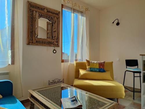 馬賽的住宿－Petit cocon à Mourepiane，客厅配有黄色沙发和镜子