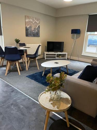 a living room with a couch and tables and a tv at Willow House by Shortstays4U 2bedroom Townhouse with free parking in town centre! in King's Lynn