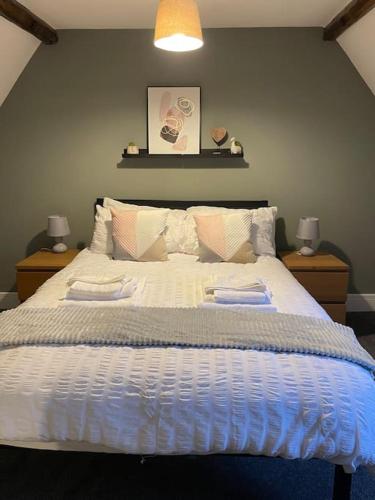 a bedroom with a large bed with two towels on it at Willow House by Shortstays4U 2bedroom Townhouse with free parking in town centre! in King's Lynn