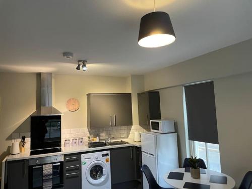 a kitchen with a refrigerator and a washer and dryer at Willow House - 2bed Townhouse with free parking!! by Shortstays4U in King's Lynn