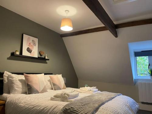 una camera da letto con un letto e asciugamani di Willow House - 2bed Townhouse with free parking!! by Shortstays4U a Kings Lynn