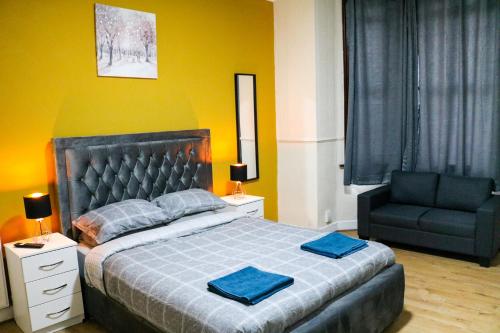 ein Schlafzimmer mit einem großen Bett und einem Stuhl in der Unterkunft AJB INTERNATIONAL LTD in London