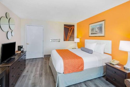 a hotel room with a bed and a flat screen tv at Howard Johnson by Wyndham Staunton in Staunton