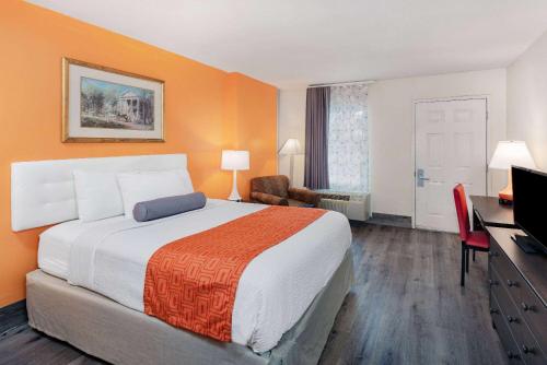 a hotel room with a large bed and a television at Howard Johnson by Wyndham Staunton in Staunton