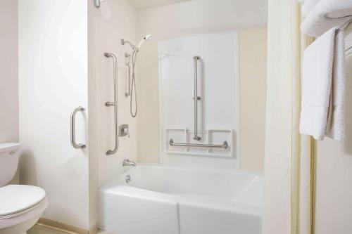 a white bathroom with a shower and a toilet at Super 8 by Wyndham Missoula/Brooks Street in Missoula