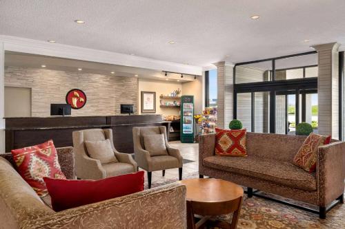a living room with couches and chairs and a table at Ramada by Wyndham Cornwall in Cornwall