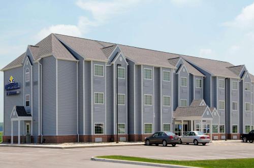 a large building with cars parked in a parking lot at Microtel Inn & Suites by Wyndham Delphos in Delphos