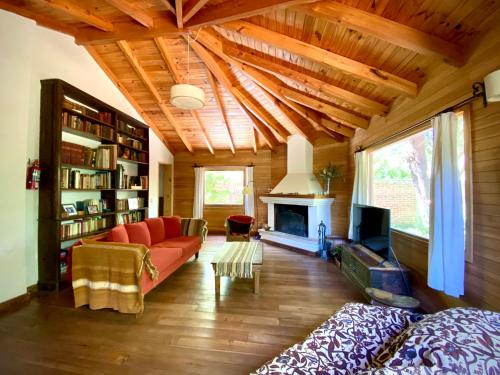 sala de estar con sofá rojo y chimenea en Casa Saurel en La Cascada en San Martín de los Andes