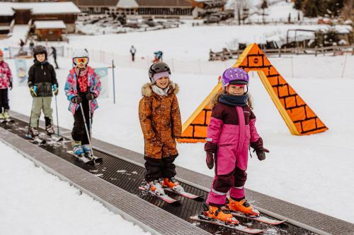 a group of children on skis in the snow at Familienhotel Huber in Valles