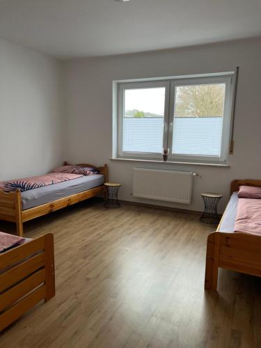 um quarto com duas camas e uma janela em F&M Wohnungen in Olpe em Olpe