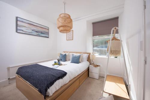 a bedroom with a bed with a swing at Keynvor Blue, Carbis Bay, St Ives in St Ives