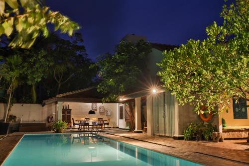 a villa with a swimming pool at night at Villa Hundira in Negombo