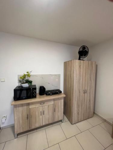 a room with two wooden cabinets and a microwave at Ubytování Zátiší Olomouc in Olomouc