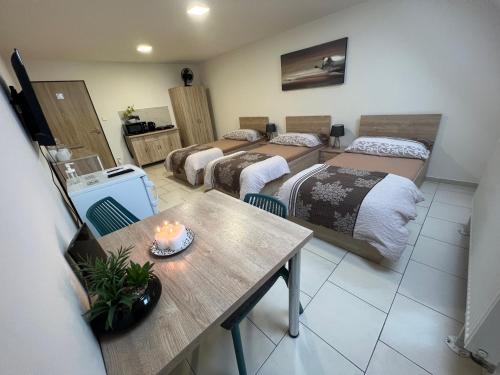 a room with three beds and a table with a candle on it at Ubytování Zátiší Olomouc in Olomouc