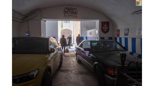 two cars parked in a garage with people walking through it at Royal Victoria Hotel in Pisa