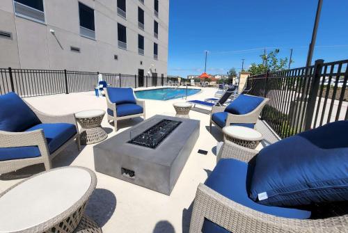 a patio with chairs and tables and a pool at Hawthorn Extended Stay by Wyndham Pflugerville in Pflugerville